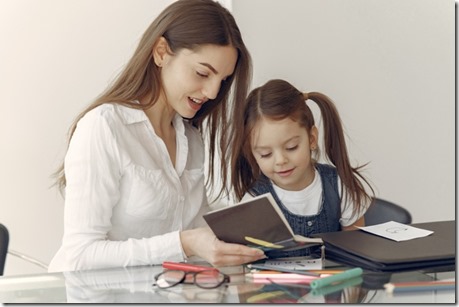 Tutor with litthe girl studying at home