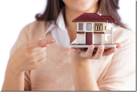 Woman holding little house