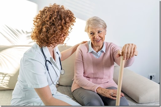 Friendly relationship between smiling caregiver in uniform and happy elderly woman. Supportive young nurse looking at senior woman. Young caring lovely caregiver and happy ward